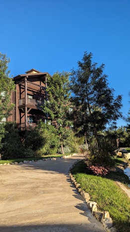 The well-maintained residential hostel building surrounded by greenery under a clear blue sky.