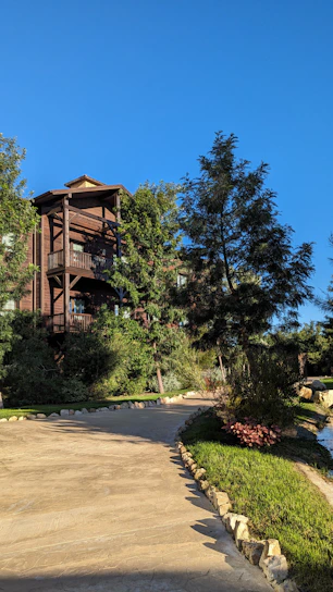A welcoming village office building surrounded by lush greenery under a clear blue sky.