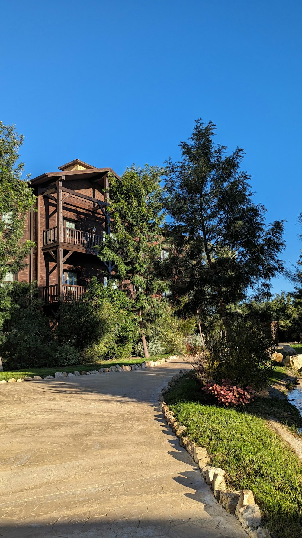 a large brown building sitting next to a lush green forest