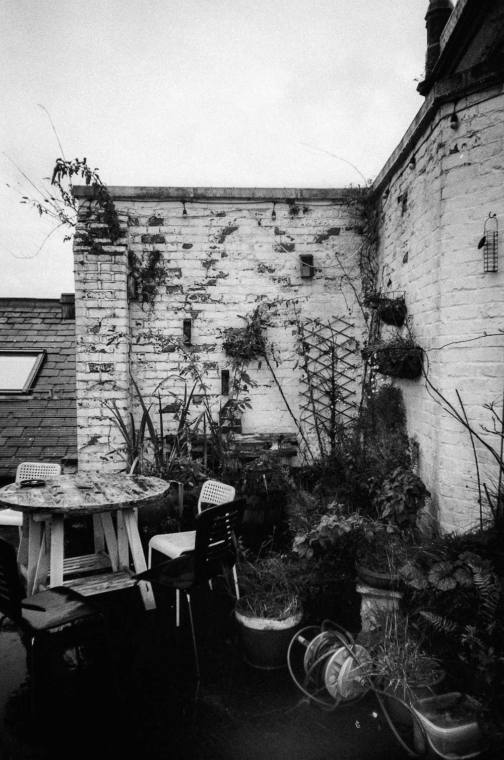 a black and white photo of a patio with a table and chairs