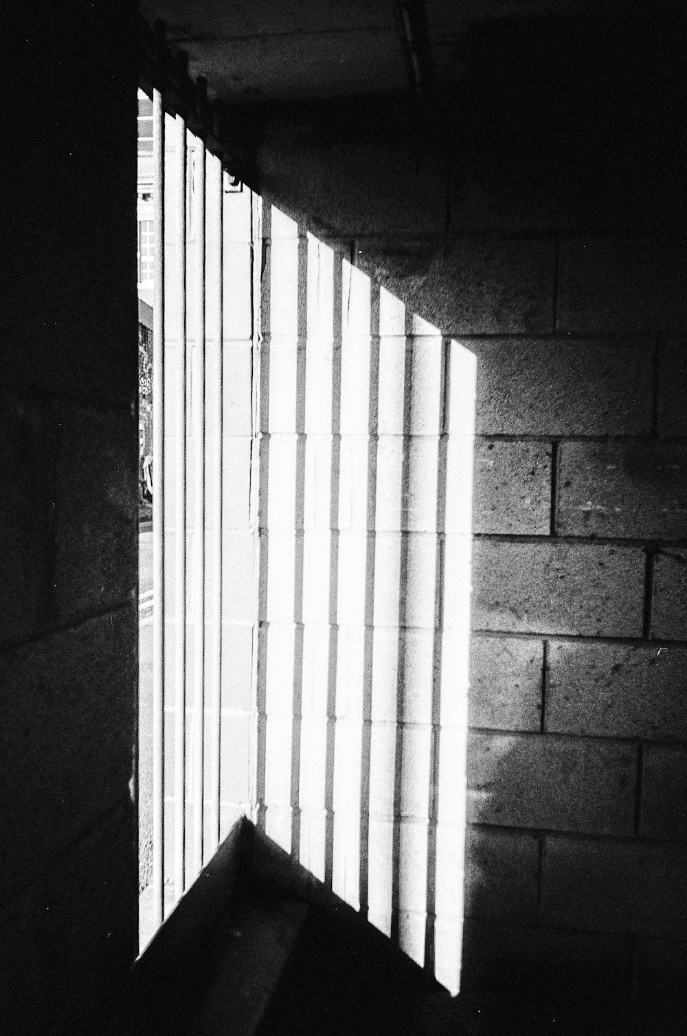 a window in a brick wall with bars on it