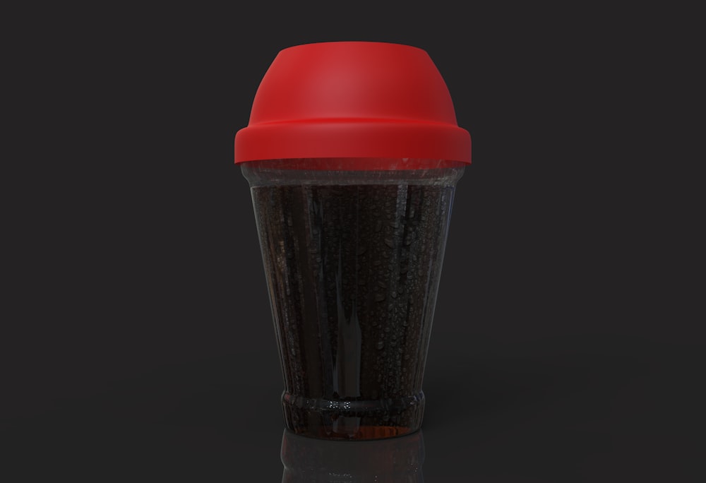 a cup of coffee with a red lid