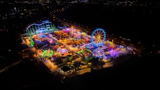 Night view of amusement park illuminated with warm lights.