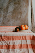 a plate of tomatoes on a striped tablecloth