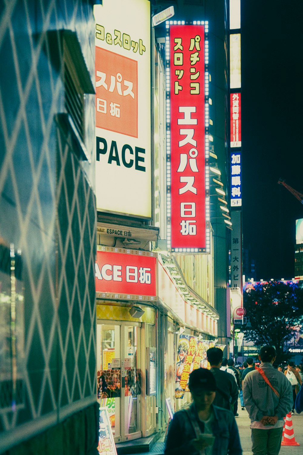 a group of people walking down a street next to tall buildings