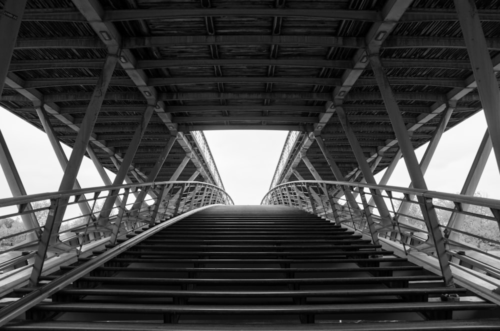 a black and white photo of a metal bridge