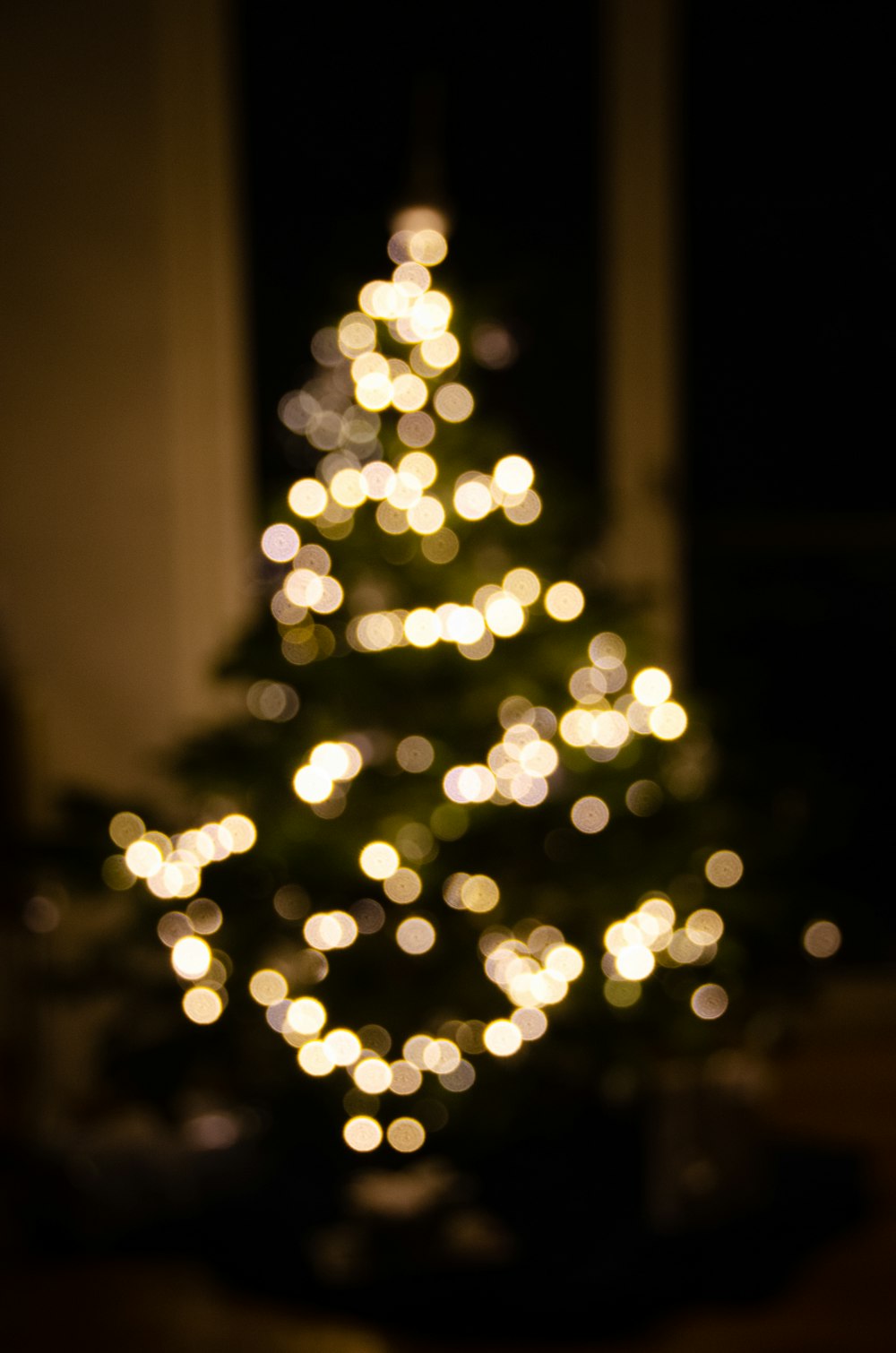 Un árbol de Navidad iluminado en una habitación oscura