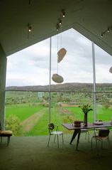 Elegant room with modern decor and large windows framing the lush greenery.