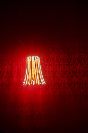 Vibrant close-up of a bold red and white designer lamp glowing warmly in a modern room.