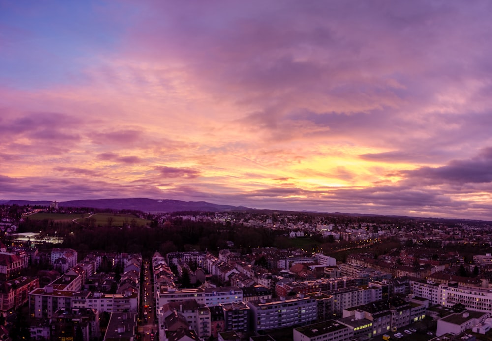 a view of a city at sunset from the top of a hill