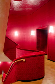 Before and after photos of a stylish interior remodel with crimson red and beige tones.