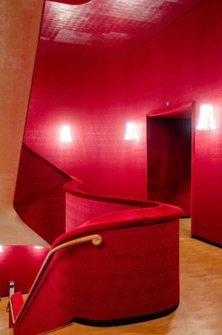 Before and after photos of a stylish interior remodel with crimson red and beige tones.