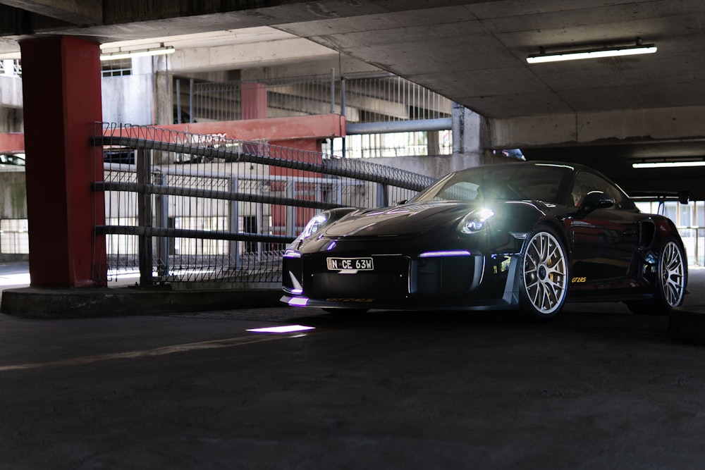 a black sports car parked in a parking garage