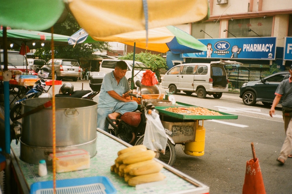 食べ物を売るカートに座っている男性