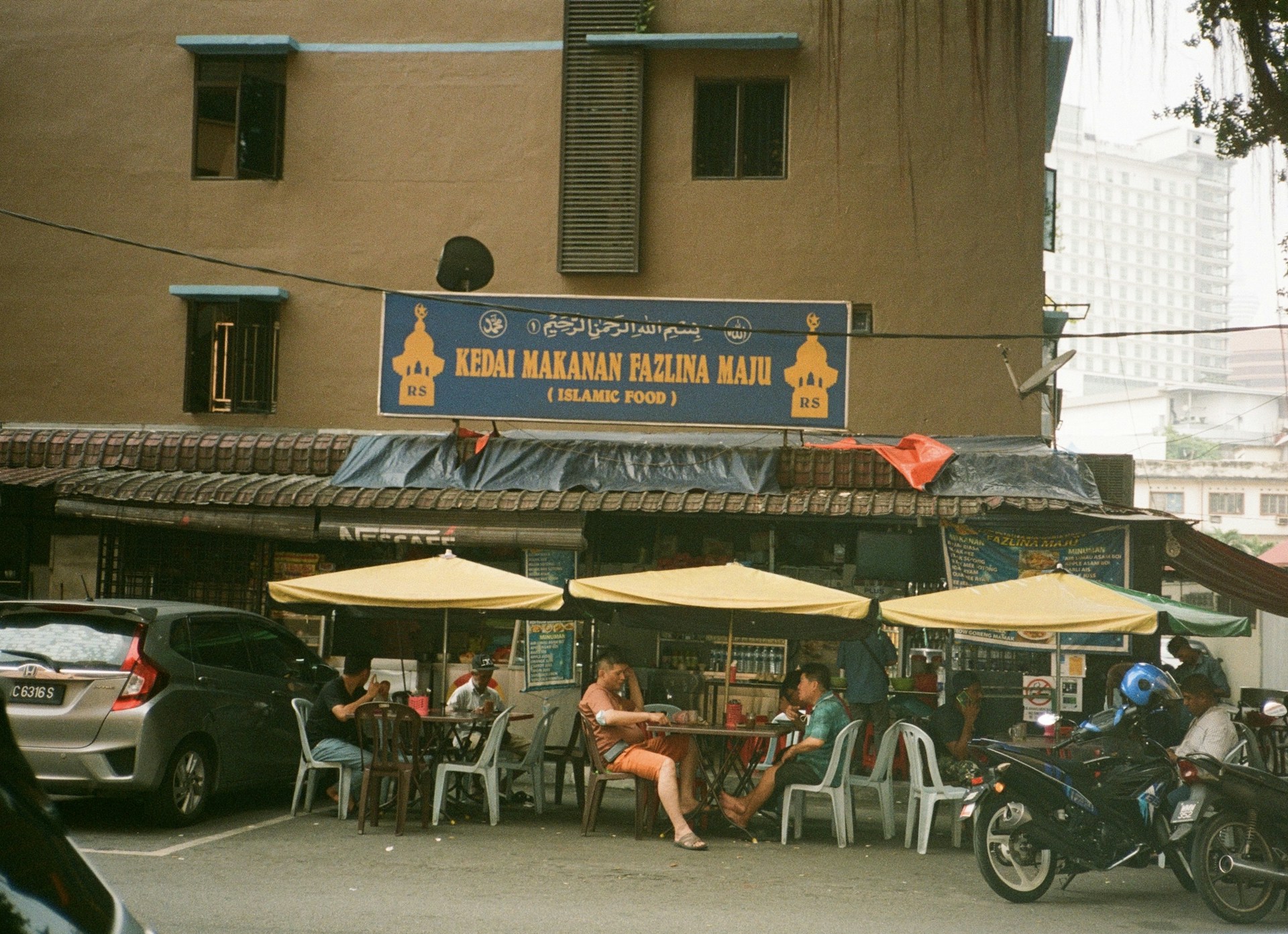 a group of people sitting outside of a restaurant