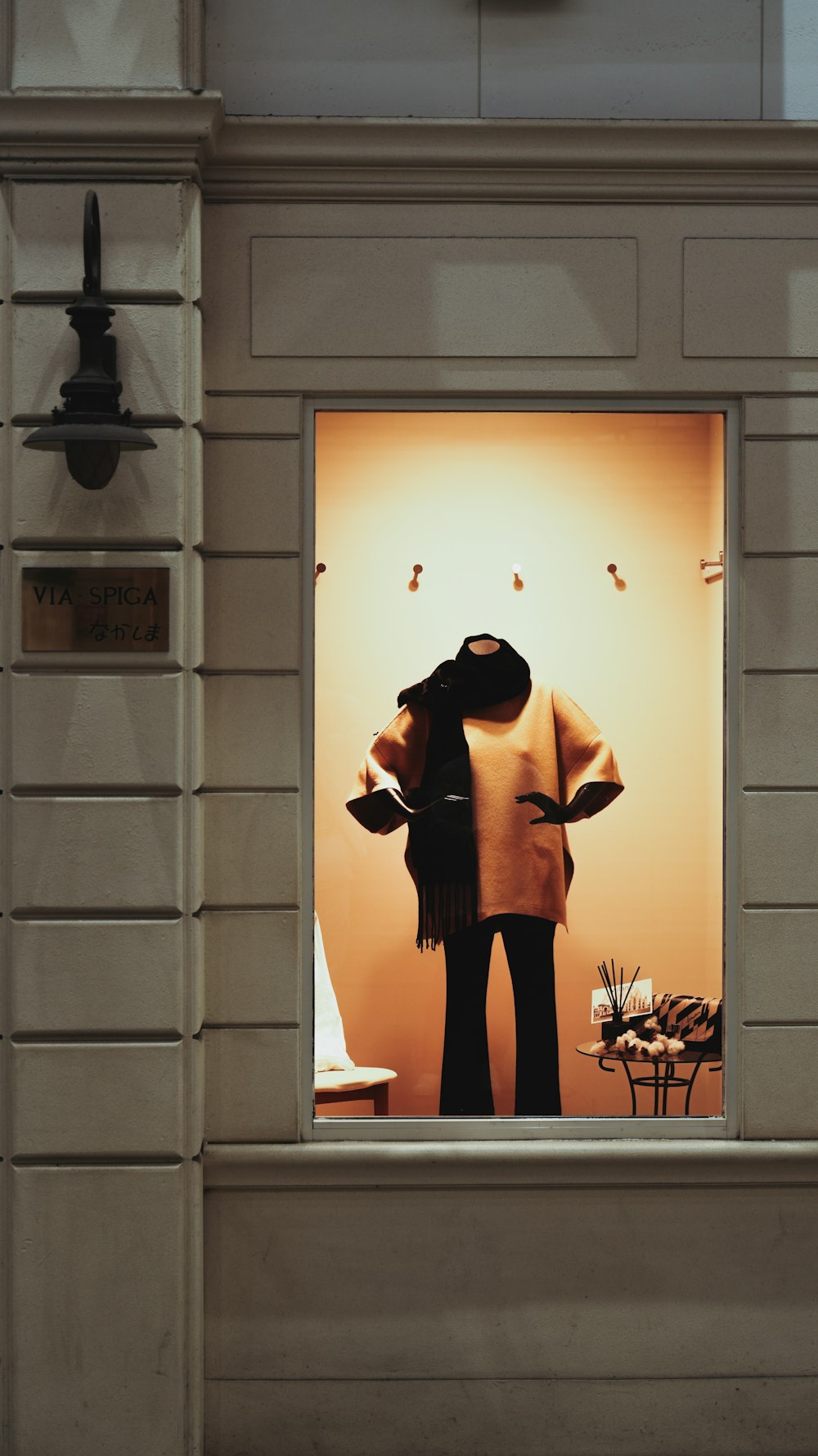 a window display of a woman's coat and hat