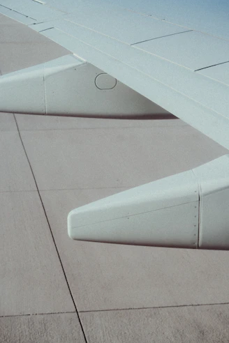 Close-up of an airplane wing showing structural details under inspection.