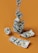 A composition of several one-hundred dollar bills arranged in artistic forms against an orange background. One bill is twisted into a spiral stack reaching upward. Another bill is crumpled into a ball, while a few others are partially unfolded on the surface.