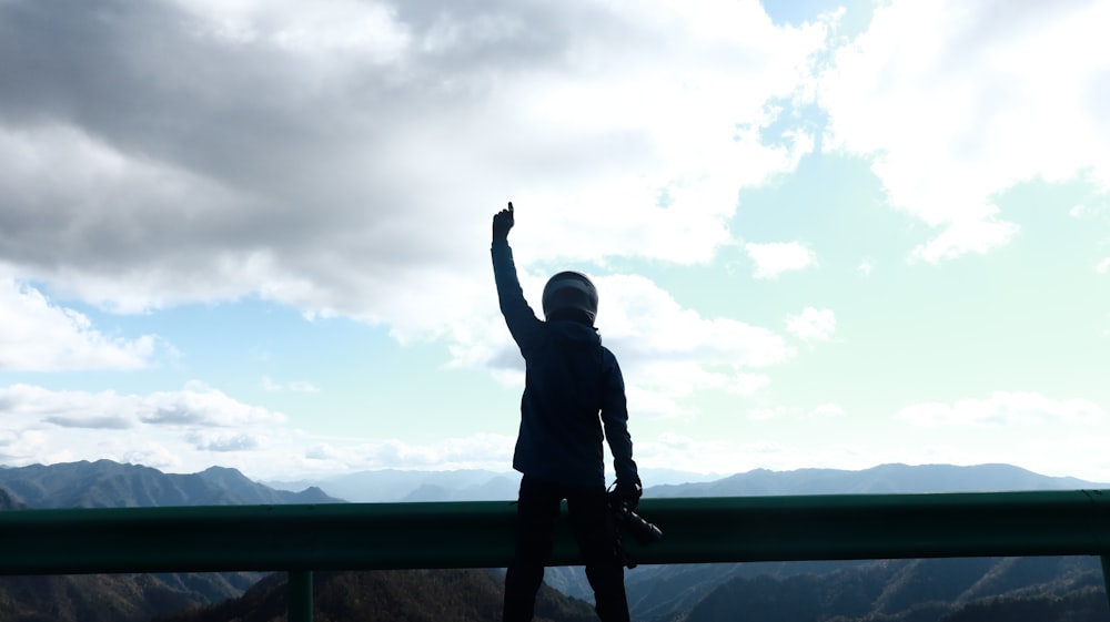 a person standing on top of a mountain with their arms in the air