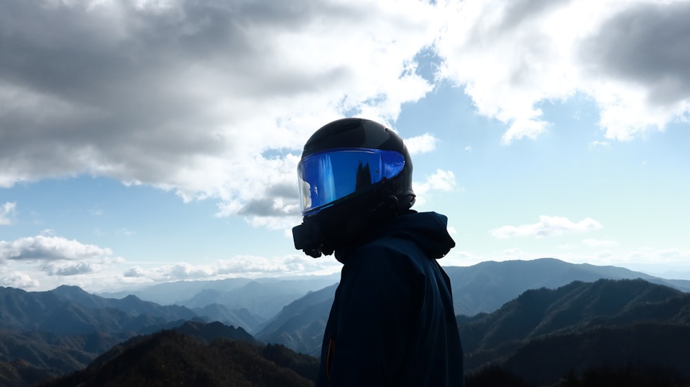 a person wearing a helmet and a scarf on top of a mountain