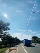 A fleet of large cargo trucks driving on a highway under a clear sky.