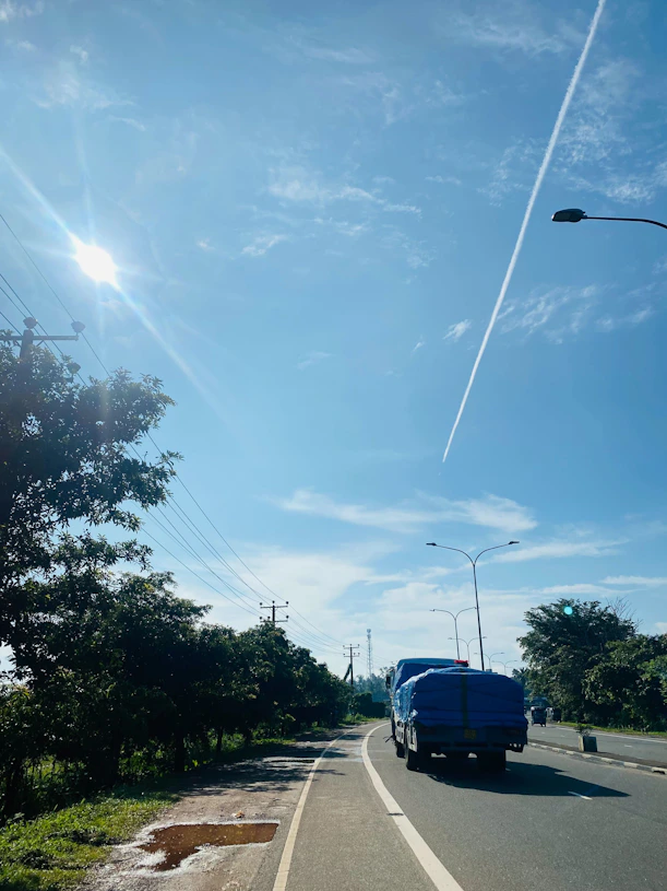 A fleet of trucks driving along a Brazilian highway with blue skies and green landscapes.