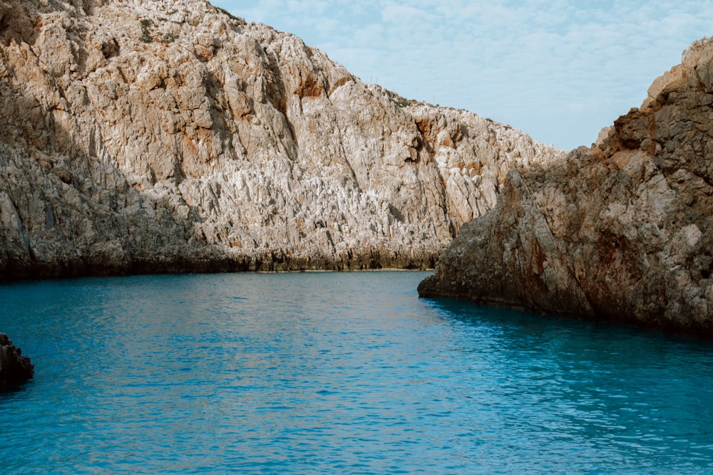 a body of water surrounded by a rocky cliff