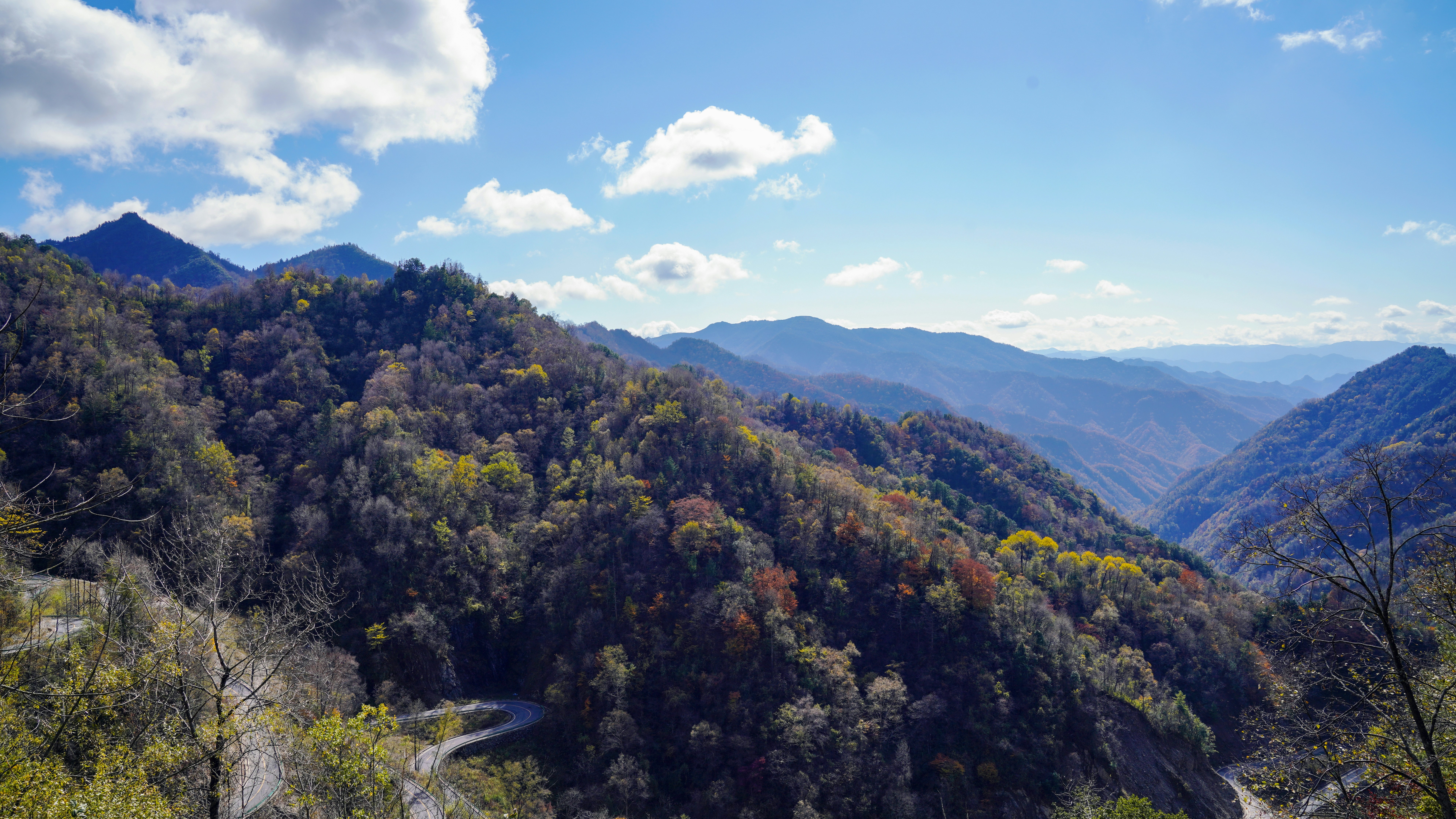 a scenic view of a winding road in the mountains