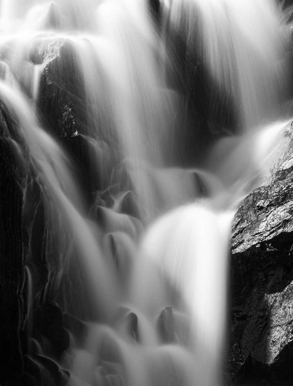 a black and white photo of a waterfall