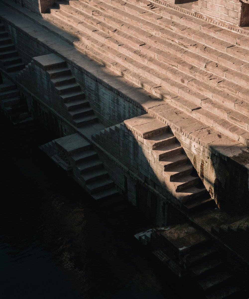 a row of stone steps next to a body of water