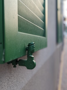 Detailed shot of the sturdy hinges and craftsmanship on a hardwood shutter.