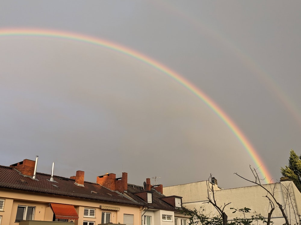 a double rainbow in the sky over a row of houses