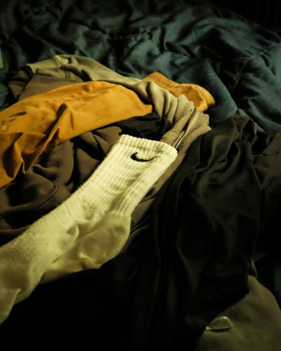 Neatly laid out clothes and a notebook on a bed the night before, prepared for the next morning