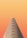 A minimalist architectural structure with a triangular, layered design set against a gradient orange background.