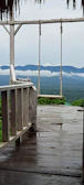 A peaceful meditation spot on a wooden deck overlooking a misty mountain valley.