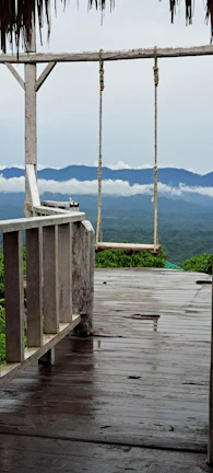 A peaceful meditation spot on a wooden deck overlooking a misty mountain valley.