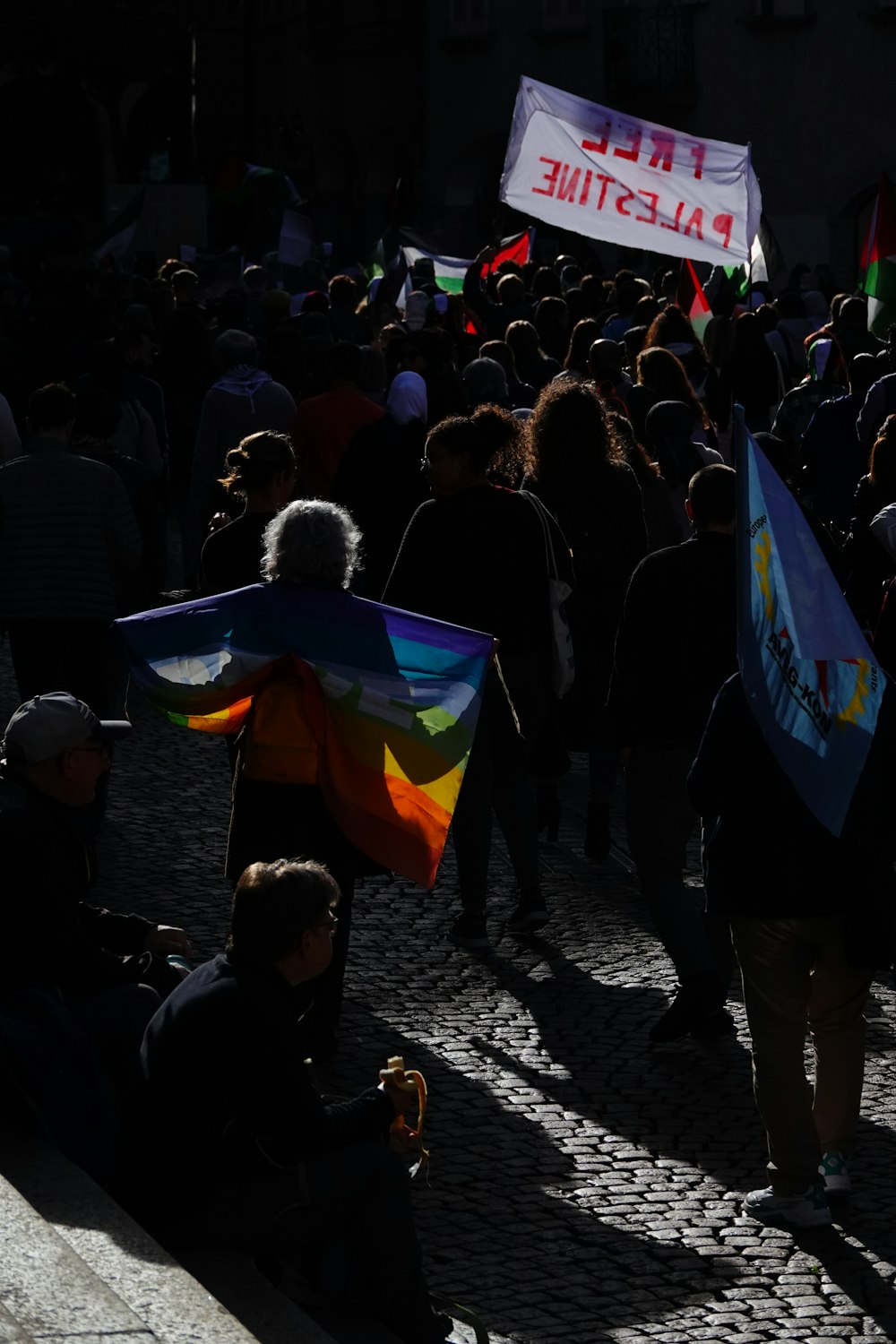 a group of people walking down a street holding flags