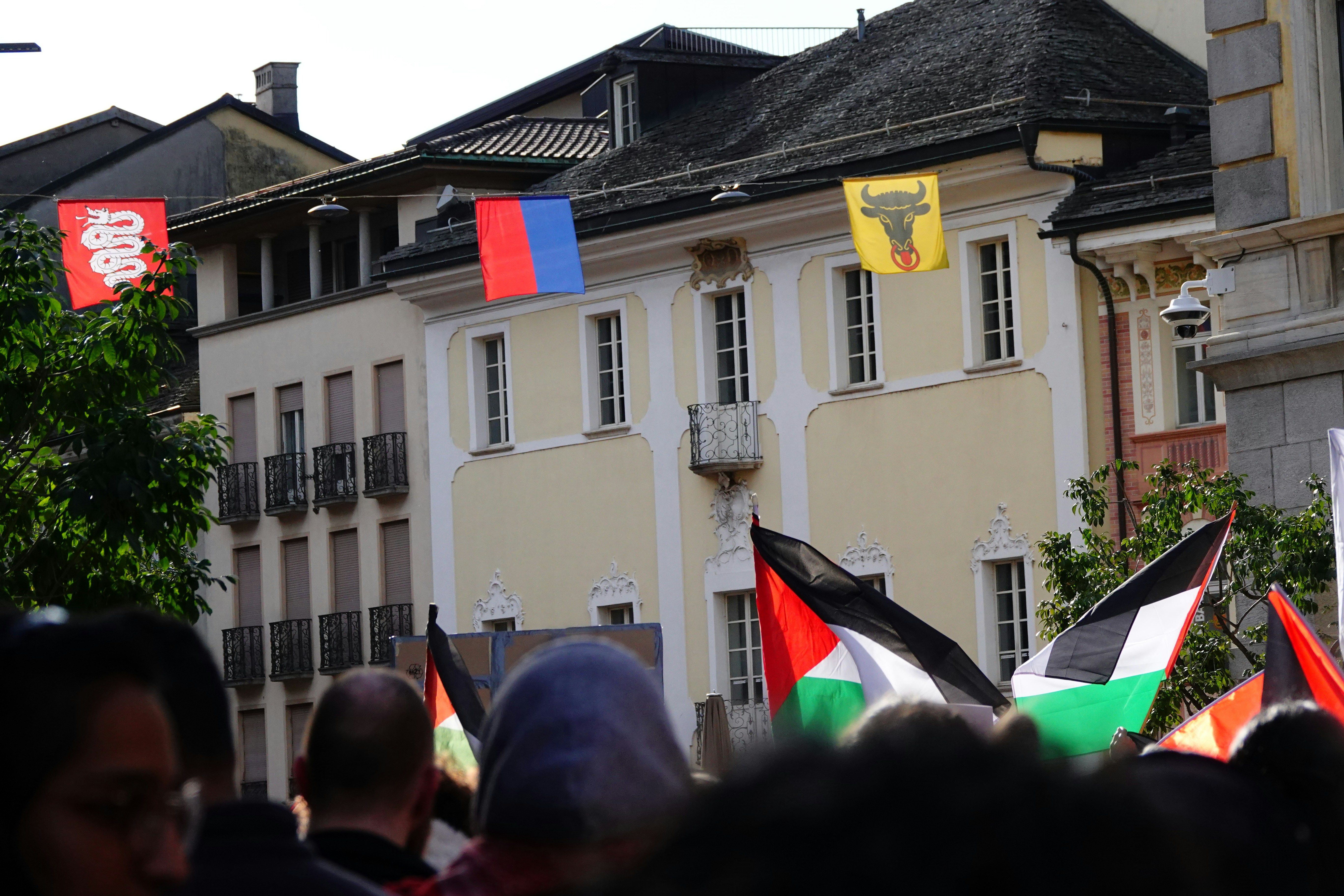 a group of people holding flags in front of a building