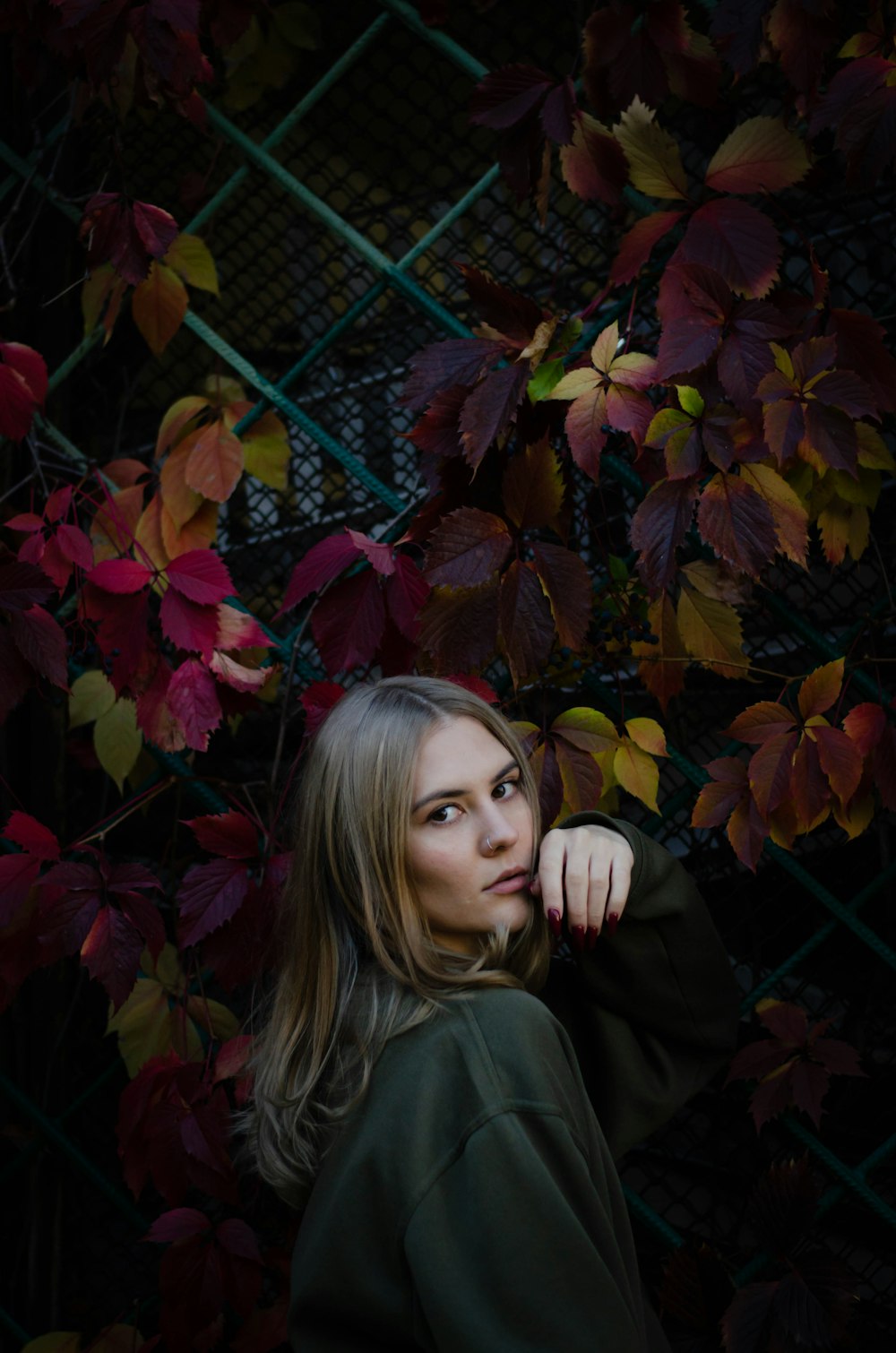 a woman standing in front of a green fence