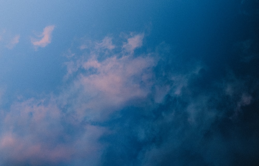 Un aereo che vola attraverso un cielo blu nuvoloso