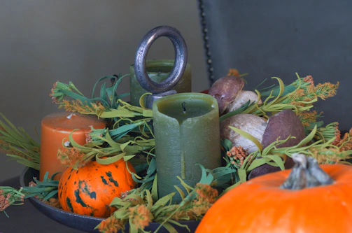 A display of golden candles arranged with autumn leaves
