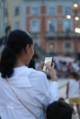 An influencer creating content with a smartphone in an urban outdoor setting.