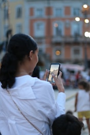 A young influencer creating content with a smartphone in an urban setting.
