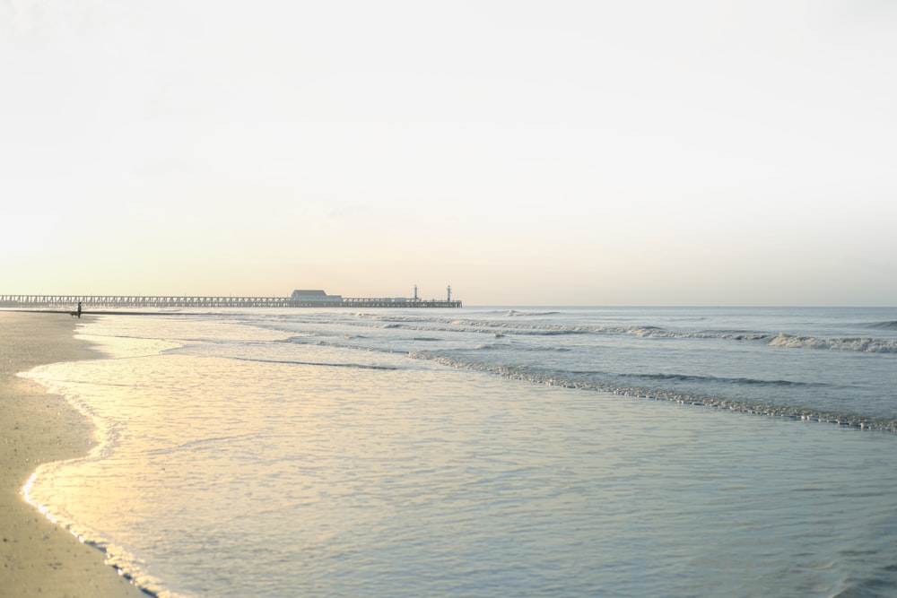 a beach with a bridge in the distance