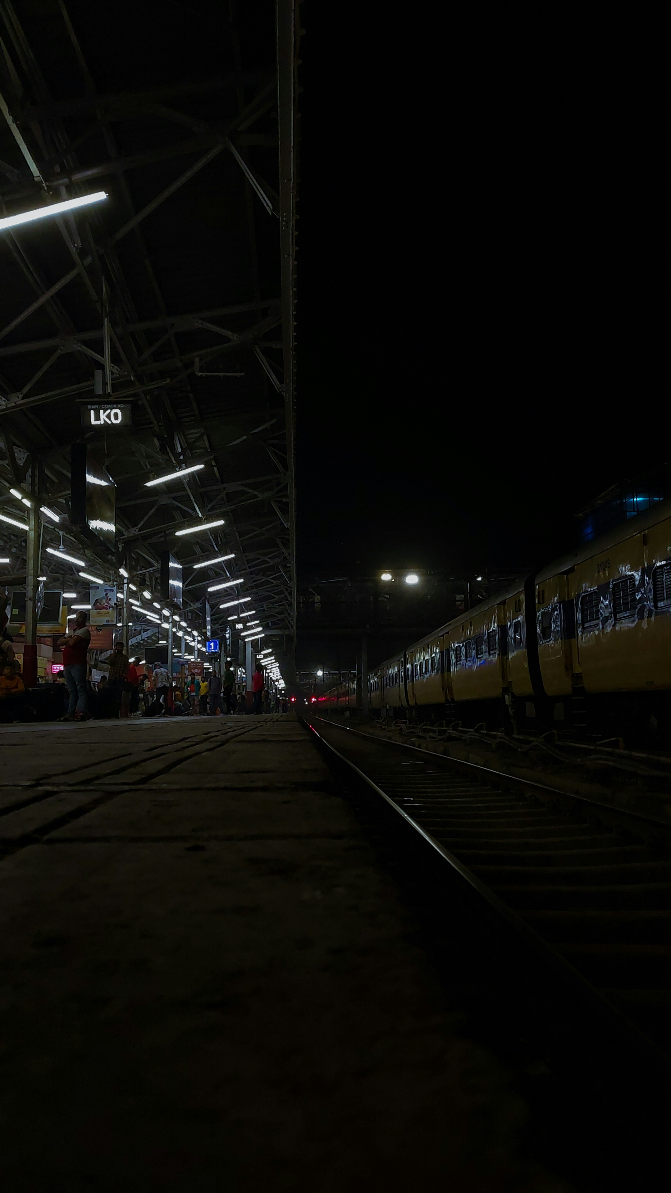 a train station at night with a train on the tracks