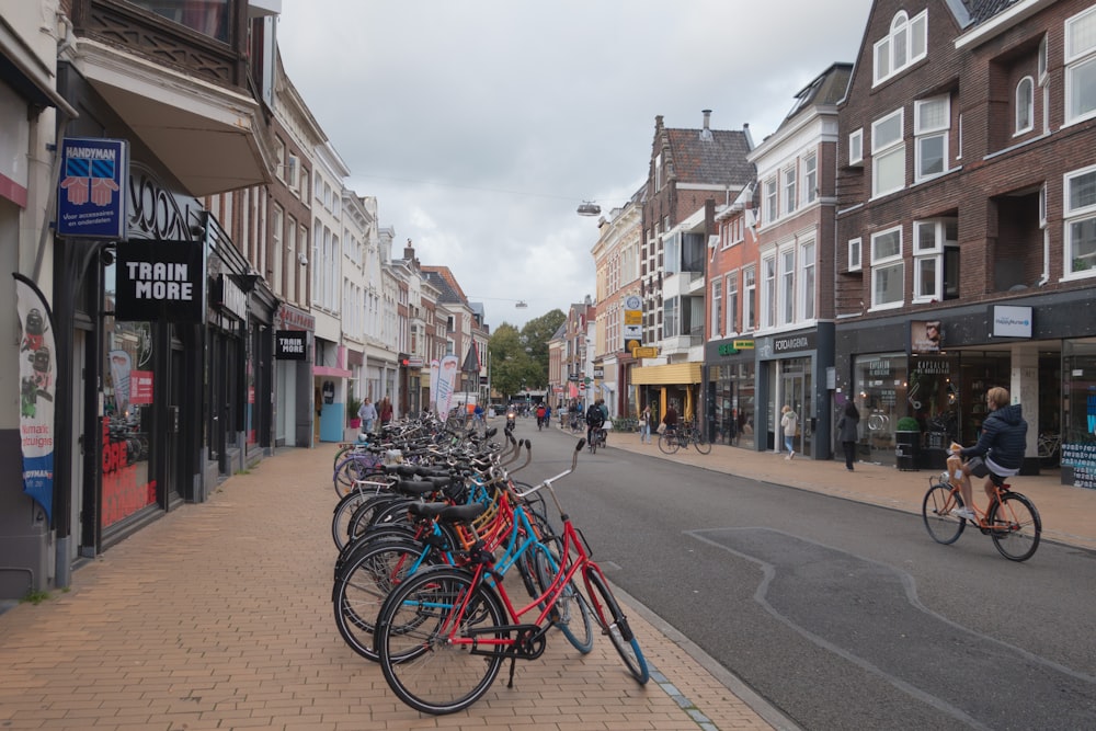 a row of bikes parked on the side of a street