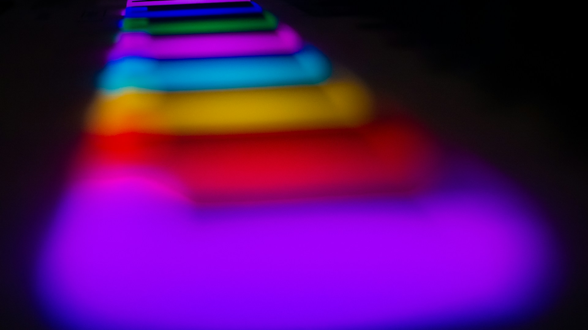 A dynamic collage of movie and TV series posters illuminated by glowing gradient lights in neon purple and electric blue.