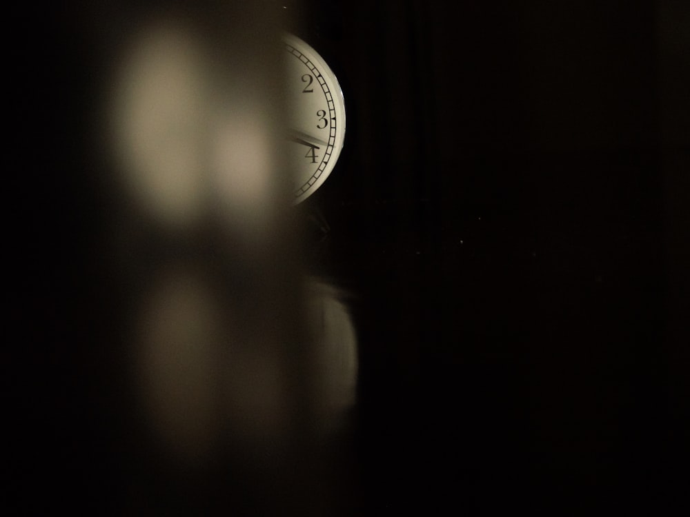 a clock sitting on top of a table in the dark