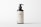 A dark brown bottle with a pump dispenser, featuring a minimalistic label displaying the text 'LBL Cosmetic Label' and additional information. The background is plain and light-colored, creating a clean, modern appearance.