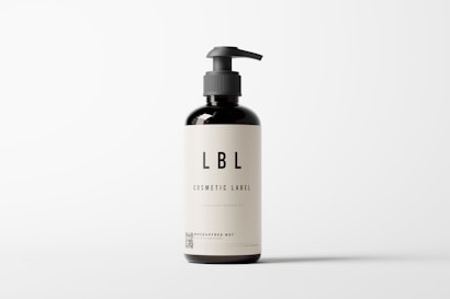 A dark brown bottle with a pump dispenser, featuring a minimalistic label displaying the text 'LBL Cosmetic Label' and additional information. The background is plain and light-colored, creating a clean, modern appearance.